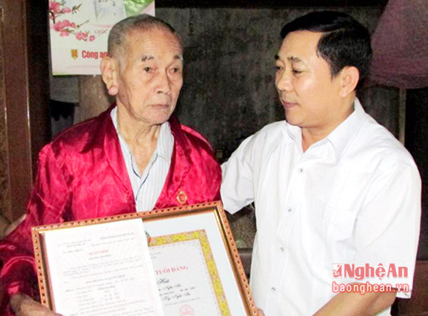 Đồng chí Phan Văn Giáp - Phó bí thư thường trực Huyện ủy Tân Kỳ trao huy hiệu 60 năm tuổi đảng cho đồng chí Trần Văn Huệ.