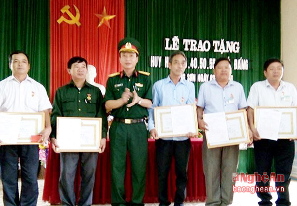 Đồng chí Lương Trọng Hòa - Ủy viên BTV Huyện ủy, Chỉ huy trưởng Ban CHQS huyện Tân Kỳ trao Huy hiệu Đảng cho các đảng viên.
