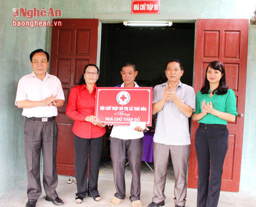 Ông Đinh Văn Thị, Phó Chủ tịch UBND, Chủ tịch Hội CTĐ thị xã Thái Hòa trao tiền hỗ trợ xây nhà cho anh Cao Xuân Nguyên