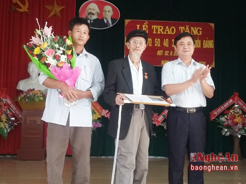 Đồng chí Thái Thanh Quý- Ủy viên dự khuyết BCH TW Đảng, Bí thư huyện ủy Nam Đàn trao tặng huy hiệu 70 năm tuổi Đảng cho đảng viên Đặng Xuân Lâm, xóm Mạnh San.
