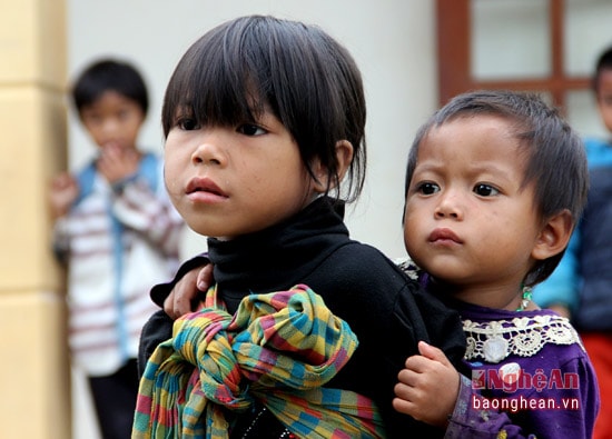 Vẫn là hình ảnh chị cõng em, nhưng ta có thể thấy được niềm vui trong ánh mắt của cả hai đứa trẻ trong ngày hội đến trường, điều mà các em thích thú hơn bao giờ hết.