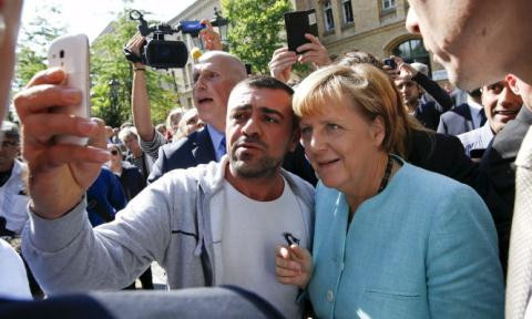 Người tị nạn chụp ảnh cùng Thủ tướng Angela Merkel. Ảnh: AFP