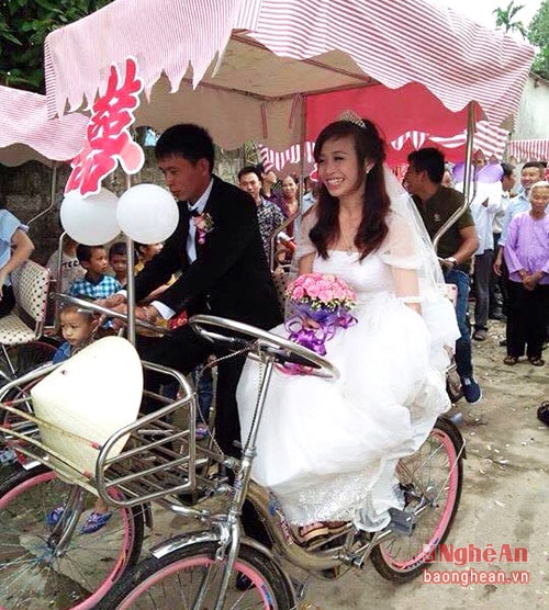 Cô dâu và chú rể trên xe đạp đôi