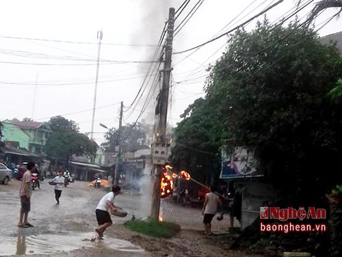 Người dân đang chữa cháy cột điện. 