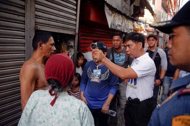 Một cảnh sát đụng độ với người dân trong cuộc bố ráp tội phạm ma túy ở Philippines. Ảnh Reuters.