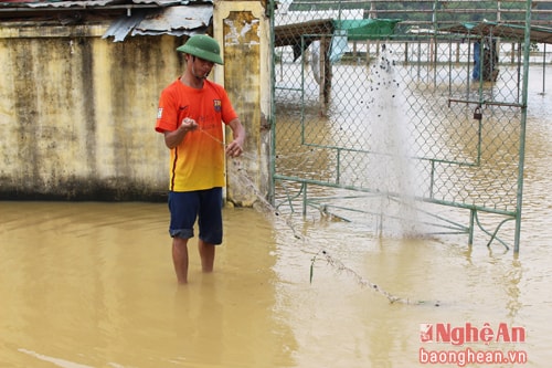  Ngoài cổng chợ, người dân chăng lưới để sửa vì bị nước cuốn trong đêm.