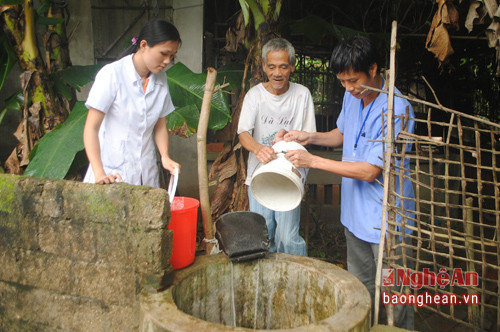 Cán bộ y tế xã Nam Trung hướng dẫn người dân thau rửa giếng khơi.