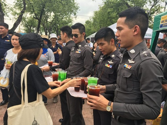 Lực lượng cảnh sát phục vụ đồ uống miễn phí cho người dân tới viếng Nhà vua.