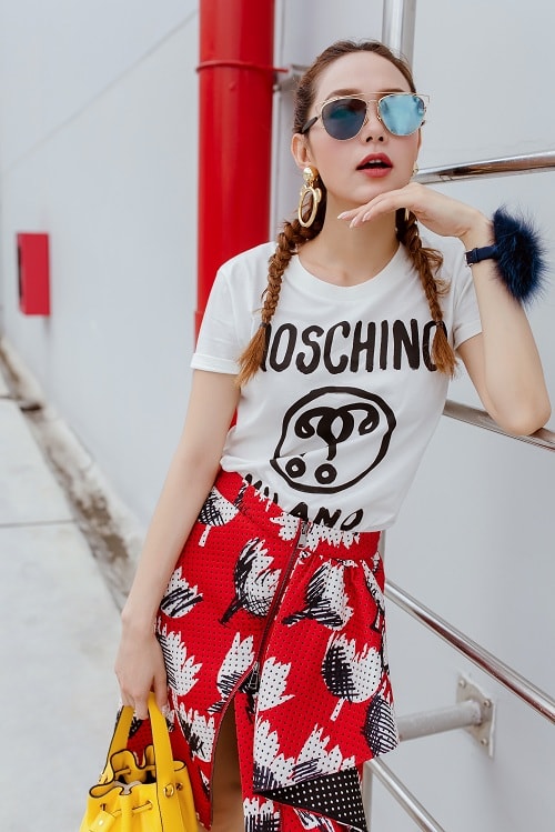 Moschino là thương hiệu thời trang yêu thích của Minh Hằng nên cô nàng còn tậu thêm chiếc áo thun lạ mắt kết hợp với chân váy rực rỡ.