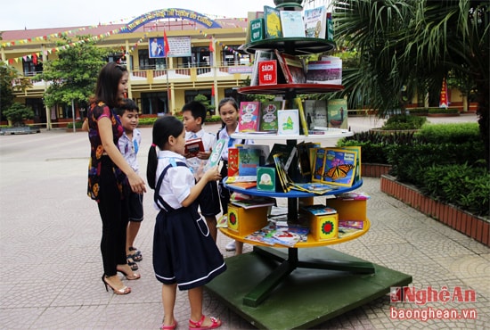 Giáo viên Trường Tiểu học Thị trấn Đô Lương hướng dẫn học trò chọn sách tại thư viên ngoài trời. 