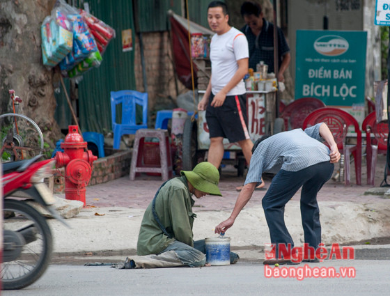 10 Không chỉ ở các chợ, bệnh viện mà tại các ngã ba ngã tư hoặc trên nhiều đoạn đường cũng bắt gặp người lang thang xin tiền. Trong hình là một thanh niên có vẻ như hai chân bị dị tật nào đó nên phải lết trên đường Đặng Thái Thân.