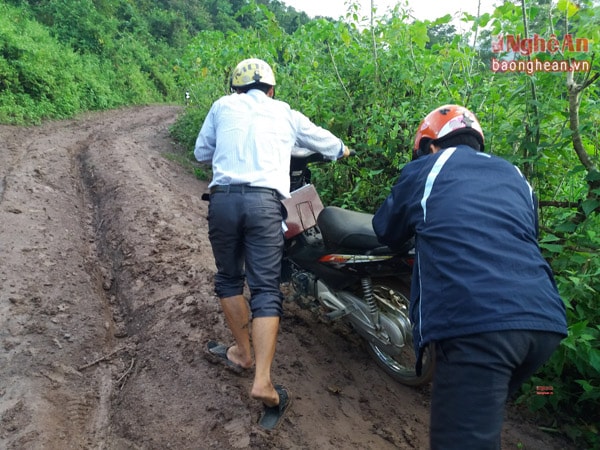 Để vượt qua 300 m đường trơn trượt này người dân phải giúp nhau đẩy từng chiếc xe máy qua dốc.