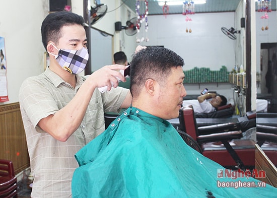 Anh Trần Đình Lai cắt tóc cho khách. 