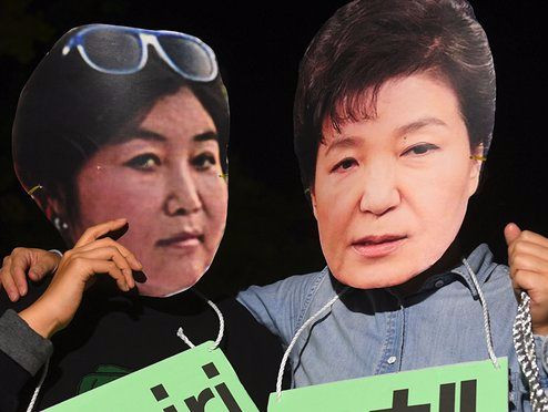 Những người biểu tình tại Hàn Quốc đeo mặt nạ hóa trang thành Tổng thống Park Geun-hye và bạn thân Choi Soon-sil. Ảnh: Theguardian