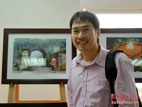 Duy Hưng bên tấm ảnh được giải của mình về thành cổ Vinh trong triển lãm Việt Nam- Đất nước- Con người