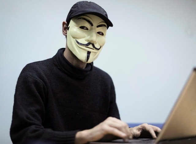 Hacker tự xưng thuộc nhóm RUH8 người Ukraine dùng mặt nạ khi trả lời phỏng vấn hãng tin Reuters - Ảnh: Reuters