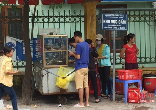 Ngay dưới bảng biển “Khu vực cấm bán hàng rong...” là một quán cơm đang đông đảo khách đến mua. Cũng như các quán cơm vỉa hè khác, chiếc xe đẩy đựng thức ăn vẫn cũ kỹ và không đậy nắp kín.