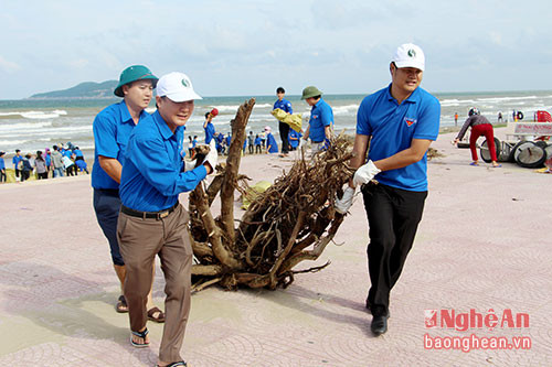 Bí thư Tỉnh đoàn Phạm Tuấn Vinh (bên trái) tham gia dọn vệ sinh biển Cửa Lò. Ảnh: Quỳnh Anh