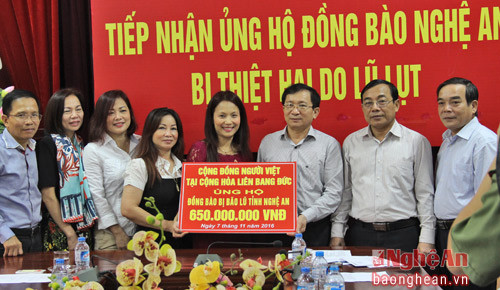 Bà Nguyễn Thị Mai Phương - Hội viên Hội Phụ nữ Việt Nam tại CHLB Đức troa quà hỗ trợ của kiều bào đến người dân tỉnh Nghệ An.