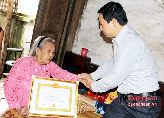 Lãnh đạo thị xã Thái Hòa trao Huy hiệu  70 tuổi Đảng cho đảng viên Phùng Thị Mai ở khối Tân Long, phường Long Sơn.