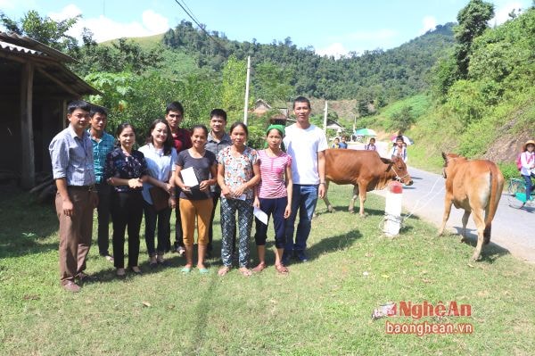 Đoàn cán bộ Báo Nghệ An trao tiền hỗ trợ làm chuồng cho các hộ được nhận bò.