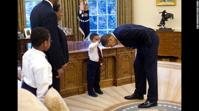 Bé trai sờ tay vào tóc ông Obama trong Phòng Bầu dục ngày 8/5/2009. Nhiếp ảnh gia Nhà Trắng Pete Souza kể: “Một nhân viên thời vụ của Nhà Trắng đưa gia đình đến Phòng Bầu dục để chụp ảnh lưu niệm trước khi chia tay Tổng thống Obama. Con trai của nhân viên này thỏ thẻ với Tổng thống rằng cậu bé vừa cắt kiểu tóc giống Tổng thống Obama, và hỏi rằng liệu cậu có thể sờ thử mái tóc của Tổng thống để xem cảm giác có giống sờ tóc mình hay không”.