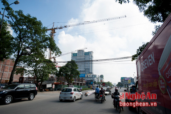 Người đi đường qua đoạn Phan Đình Phùng gần ngã tư chợ Vinh không khỏi giật mình khi chiếc cẩu tháp của công trình xây dựng bên đường lướt qua trên đầu mỗi khi quay trở.