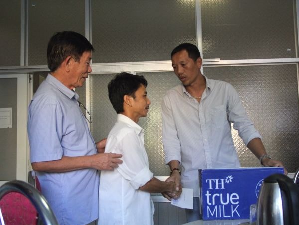 Giám đốc điều hành Hồ Văn Chiêm và HLV Nguyễn Đức Thắng trao quà cho người nhà các bệnh nhi.