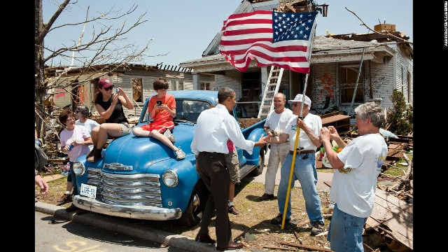 Obama chào hỏi cụ ông Hugh Hills, 85 tuổi, trước ngôi nhà bị lốc xoáy phá hỏng ở Joplin, Missouri ngày 29/5/2011. Đó là cơn lốc gây nhiều thương vong nhất trên đất Mỹ kể từ khi Cơ quan Thời tiết Quốc gia bắt đầu lưu trữ hồ sơ vào năm 1950. Gần 160 đã thiệt mạng trong thiên tai.