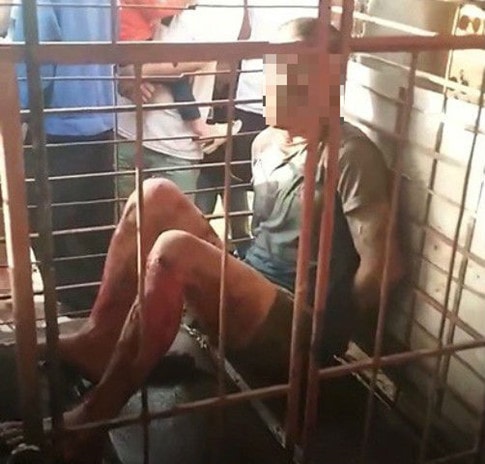 Người đàn ông bị nhốt trong lồng sắt vì nghi trộm chó. ẢNH CẮT TỪ CLIP. 