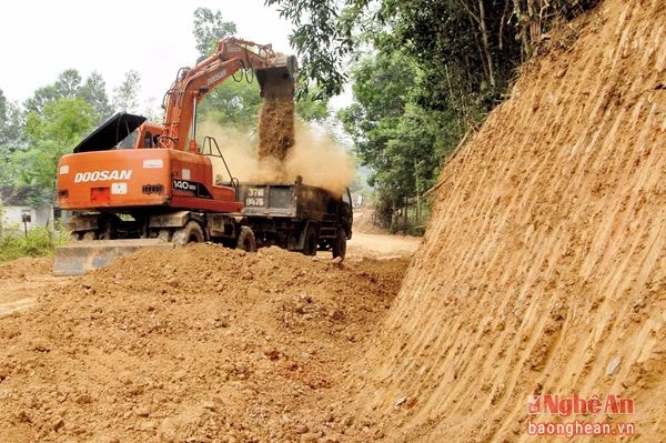 Huy động máy móc mở đường làm nông thôn mới. Ảnh: P.V