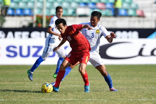 Bóng đá Malaysia (trắng) đang đối diện với một lệnh cấm từ FIFA nếu như rút khỏi AFF Cup 2016. 