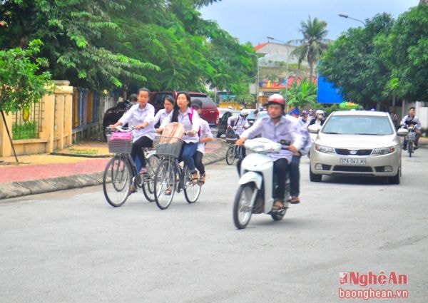 Một số học sinh Trường THPT dân lập Nguyễn Trường Tộ đi xe máy đến trường.