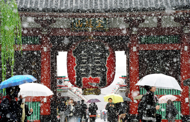 Ít nhất 13 người đã bị thương, chủ yếu do trượt ngã khi đi trên tuyết, trong đó có 4 trường hợp bị gãy xương. Trong ảnh, du khách thích thú ngắm tuyết trước đền Sensoji, một trong những điểm du lịch nổi tiếng nhất ở Tokyo, hôm nay. Ảnh: Asahi Shimbun