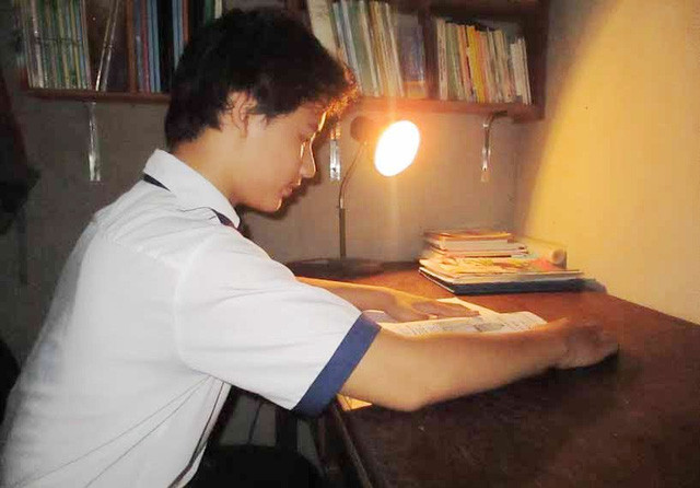 Em Phạm Quốc Đạt, một trong ba em học sinh sáng chế nên “máy báo lũ tự động” đang xem lại tài liệu về mô hình ý nghĩa này.