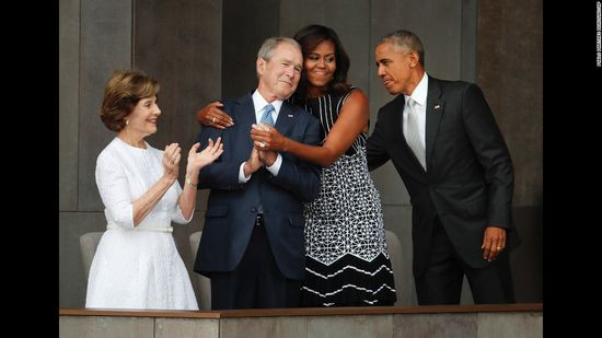 Đệ nhất Phu nhân Michelle Obama ôm cựu Tổng thống George W. Bush trong lễ trao tặng bảo tàng mới Smithsonian lưu giữ lịch sử người Mỹ gốc Phi. Bảo tàng khánh thành tại Washington hôm 24/9/2016. 