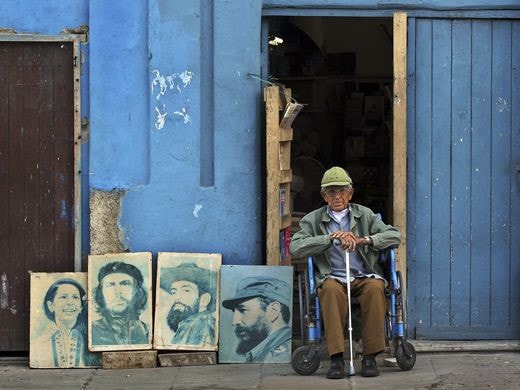 Một ông cụ với những bức ảnh chân dung về lãnh tụ cách mạng Cuba Fidel Castro và Che Guevara ở bên ngoài một căn nhà gỗ. (ảnh: AP). 