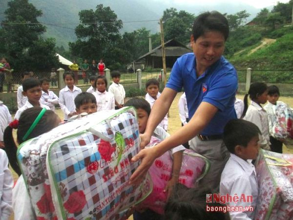 Đại diện Chi đoàn thanh niên cơ quan UBND huyện Kỳ Sơn trao quà cho học sinh nghèo ở xã Hữu Kiếm