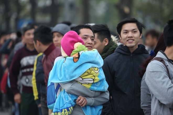 Ông bố này đưa theo cả con trai đi cùng để xếp hàng chờ mua vé. Anh khoác một tấm chăn dày và mặc rất ấm cho cháu bé để chống cái lạnh, sương giá vào sáng sớm. 