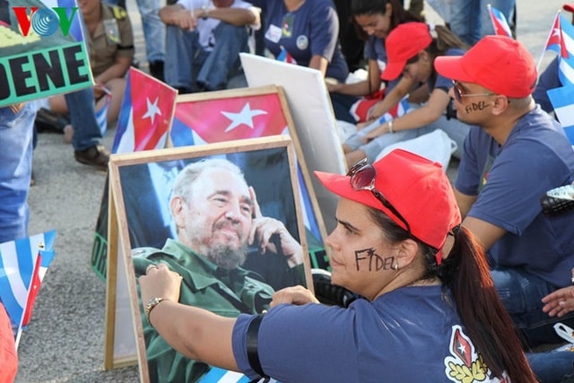 Người dân cầm theo di ảnh của Fidel Castro và viết tên ông lên mặt.