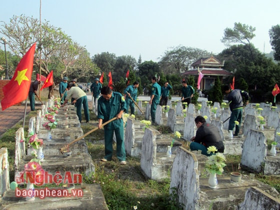 Lực lượng vũ trang, dân quân tự vệ và đoàn viên tham gia dọn vệ sinh, phát quang cây cỏ xung quanh nghĩa trang.