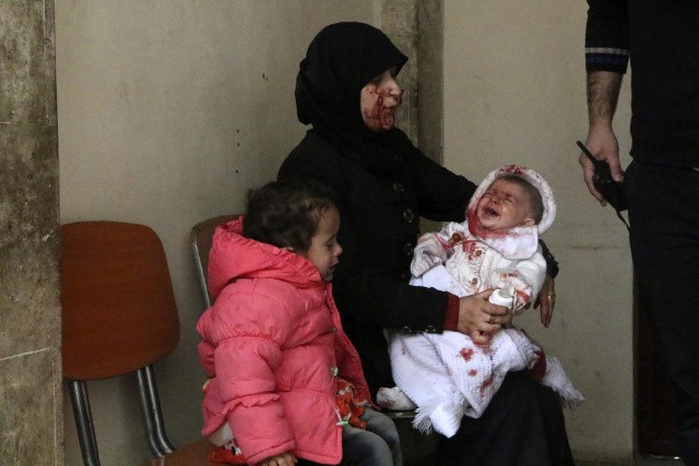 Một người sống sót giữ cô khóc em bé trong một bệnh viện ở quận al-Sakhour Aleppo, sau khi những nhà hoạt động cho biết là một quả bom thùng được thả xuống huyện Haydariye Aleppo của lực lượng trung thành với Syria của Tổng thống Bashar al-Assad, ngày 09 tháng 3 năm 2014. REUTERS 