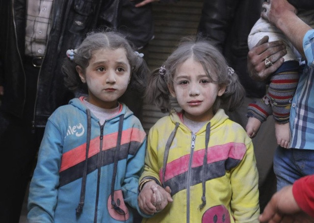 Cô gái sống sót sau những gì các nhà hoạt động cho biết là một cuộc tấn công tên lửa đất đối đất bởi lực lượng của Syria của Tổng thống Bashar al-Assad, nắm tay tại huyện Bab al-Hadeed Aleppo của 07 tháng 4 năm 2015. REUTERS / Abdalrhman Ismail