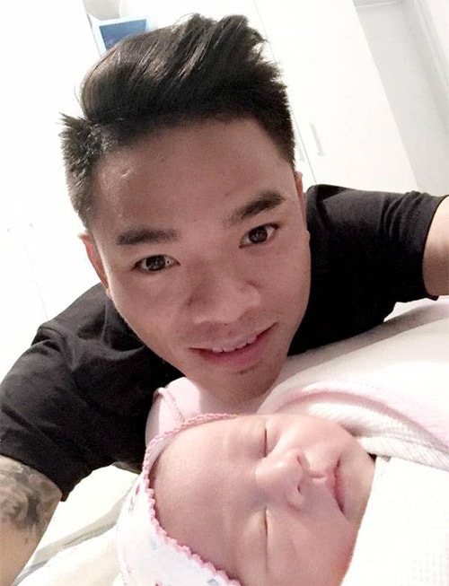 Nguyên Mạnh vừa chơi với con ba tháng tuổi, vừa xem trận chung kết lượt đi.