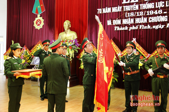 Đồng chí Hà Tân Tiến gắn Huân chương bảo vệ tổ quốc hạng Nhì lên lá cơ quyết thắng của LLVT Thành phố Vinh.