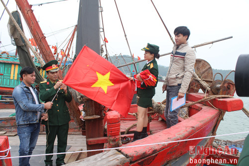 Cán bộ ĐVTN Bộ CHQS tỉnh trao cờ Tổ quốc cho chủ tàu thuyền.