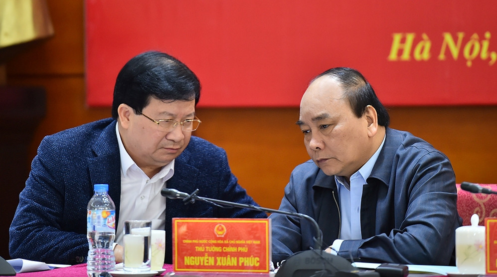 Thủ tướng Nguyễn Xuân Phúc trao đổi với Phó Thủ tướng Trịnh Đình Dũng về tình hình mưa lũ tại miền Trung. Ảnh: VGP/Quang Hiếu