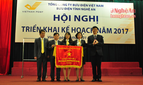 Thừa ủy quyền của Thủ tướng Chính phủ, đồng chí Lê Xuân Đại - Phó Chủ tịch UBND tỉnh trao Cờ thi đua xuất sắc của Chính phủ năm 2016 cho Bưu điện Nghệ An