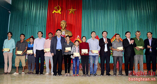 Bí thư Tỉnh ủy Nguyễn Đắc Vinh và các đồng chí đi cùng đoàn trao quà cho các hộ nghèo phường Quỳnh Xuân và xã Quỳnh Vinh.