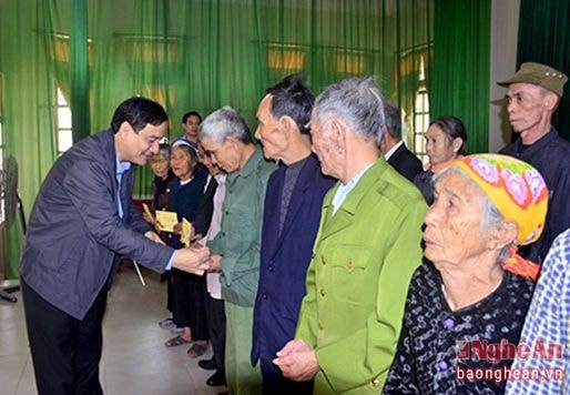 Bí thư Tỉnh ủy Nguyễn Đắc Vinh tặng quà cho các hộ nghèo, gia đình chính sách huyện Quỳnh Lưu. Ảnh: Thành Duy.